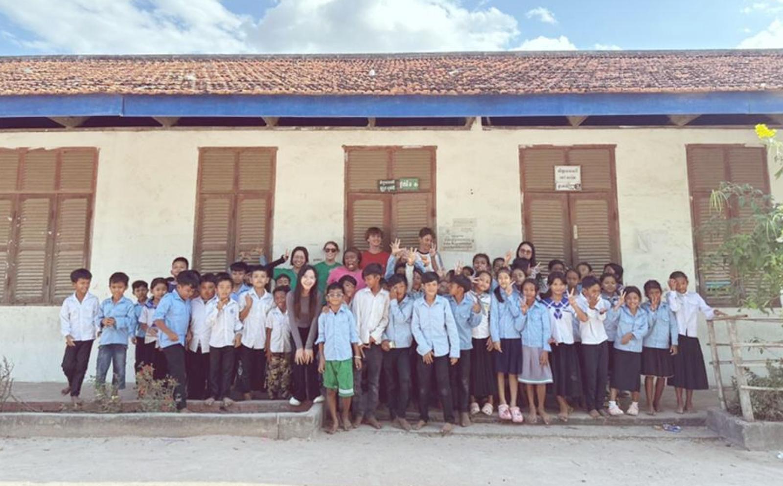 公衆衛生活動中の大学生インターン小嶋奏楽とカンボジアの学校の子供たち